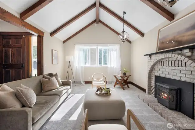 Vaulted ceilings, wood beams, and bright windows make the home feel open yet cozy.