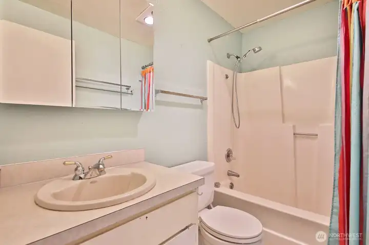 Full bath located off the hallway near bedrooms. The floor here is vinyl flooring.