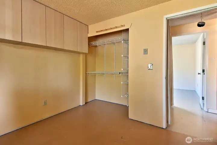Bedroom #2 closet and built-ins with the entry to Bedroom #3 across the hall. The Bathroom is located in the hallway to the right.