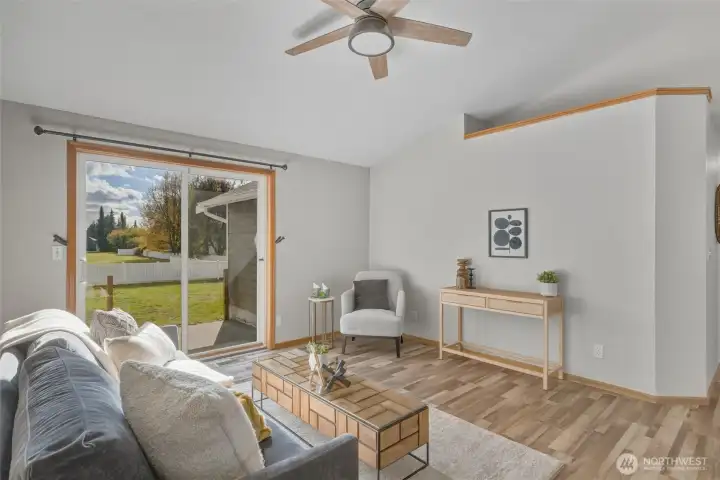Looking through the living room to the sliding glass doors out to the patio and large fenced backyard.