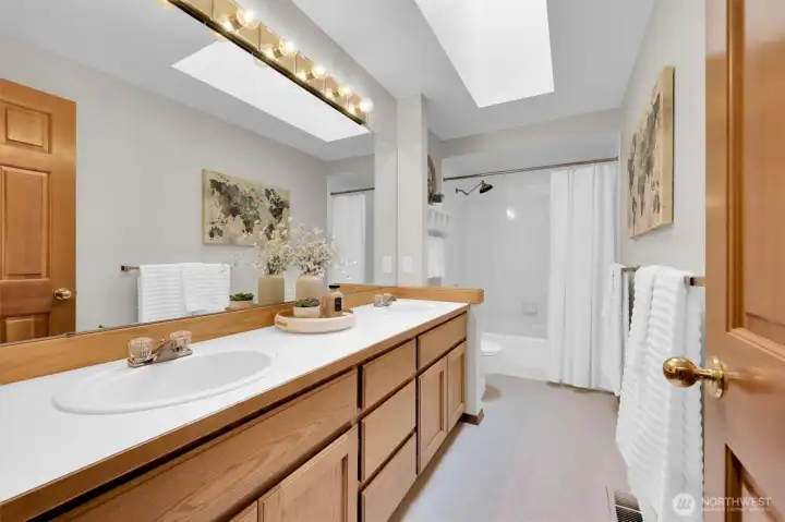 Main Bath with dual sinks and skylight.