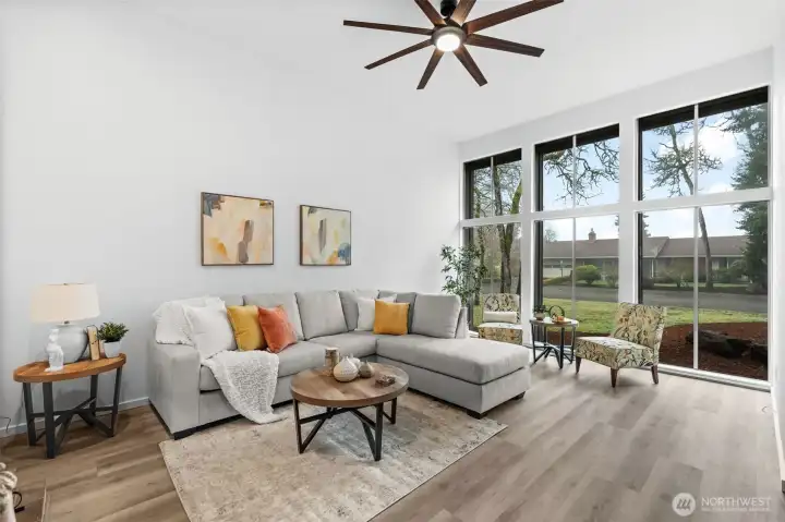 The front room has soaring ceilings and floor to ceiling windows