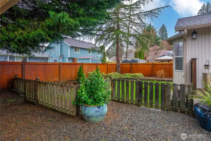 Charming garden fence keeps pets safe and plants protected.