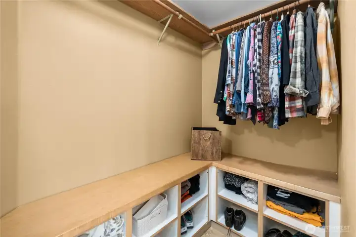 Organized walk-in closet featuring built-in shelving.