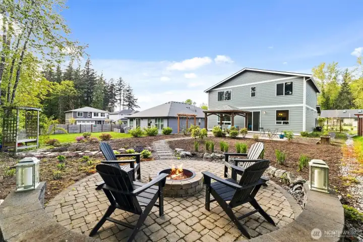 Firepit in the private backyard with stepping stone path from the house