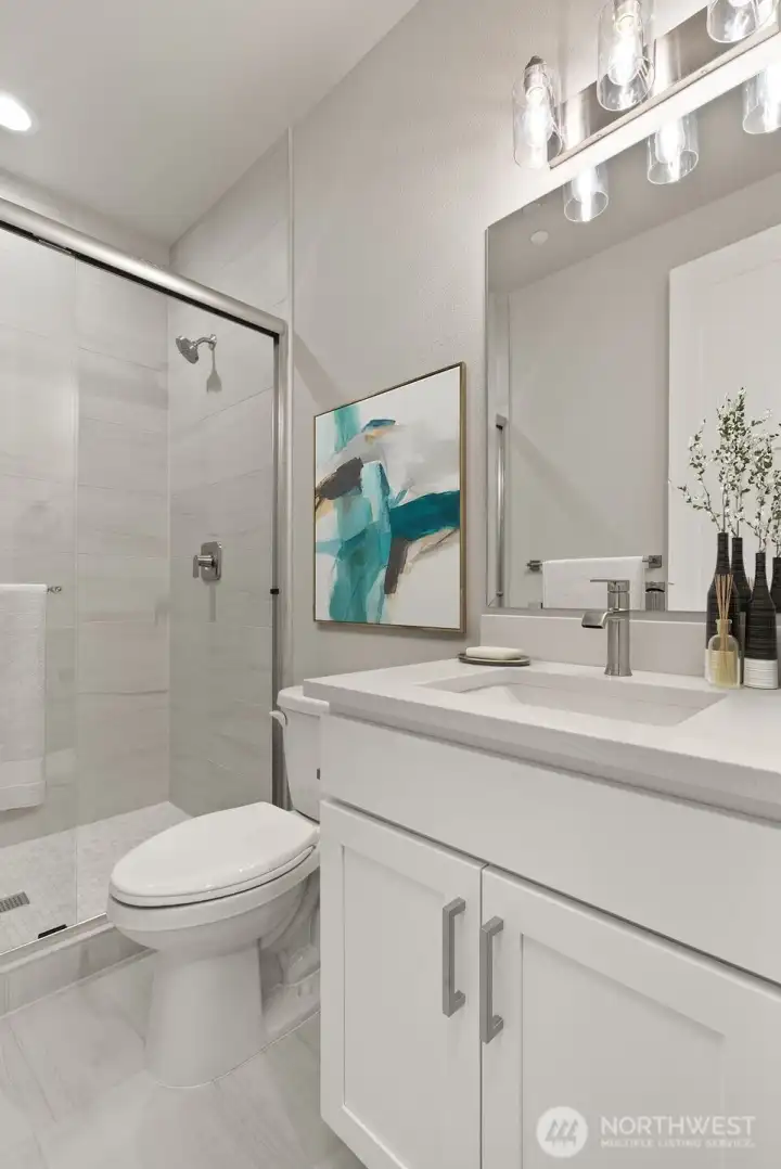 Guest Bath features tile shower with glass surround.