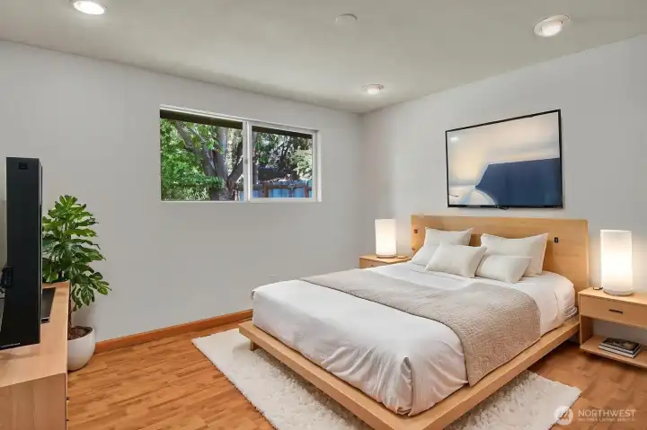 A bright, spacious primary bedroom featuring a serene north-facing window and a custom built-in drawer system in the closet A bright, spacious primary bedroom featuring a serene north-facing window and a custom built-in drawer system in the closet
