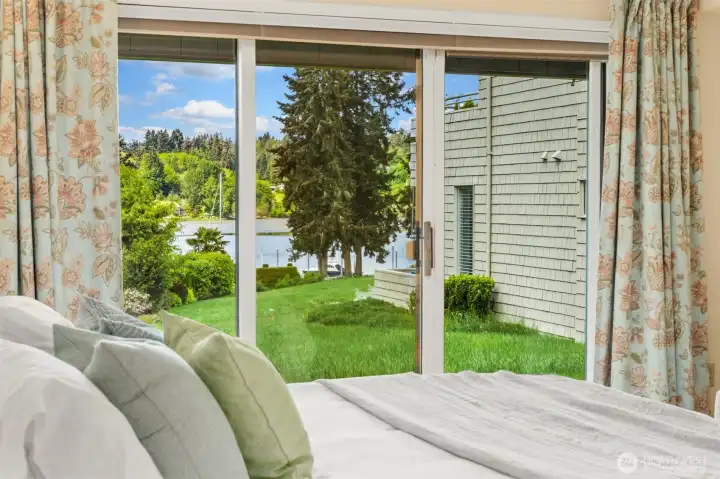 Lower level bedroom with sliding doors to views of gardens and water.