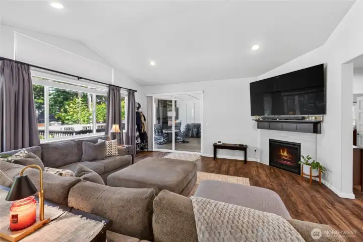 Gather around the cozy fireplace while enjoying views of the backyard and easy access to the covered outdoor living space.