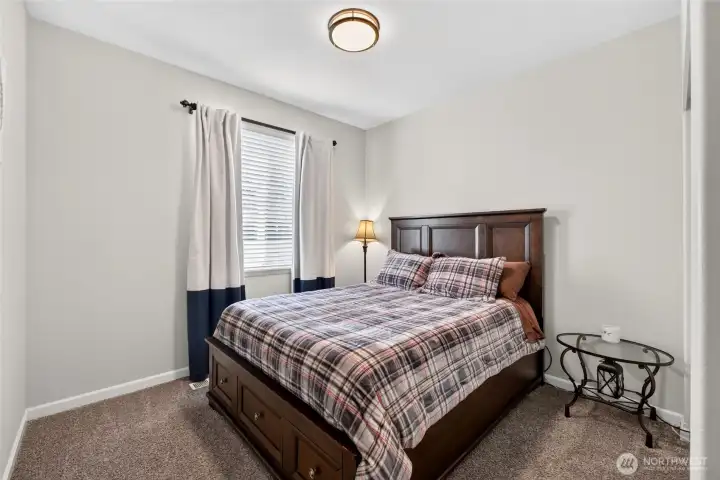 Comfortable guest bedroom with abundant natural light and flexible use options.