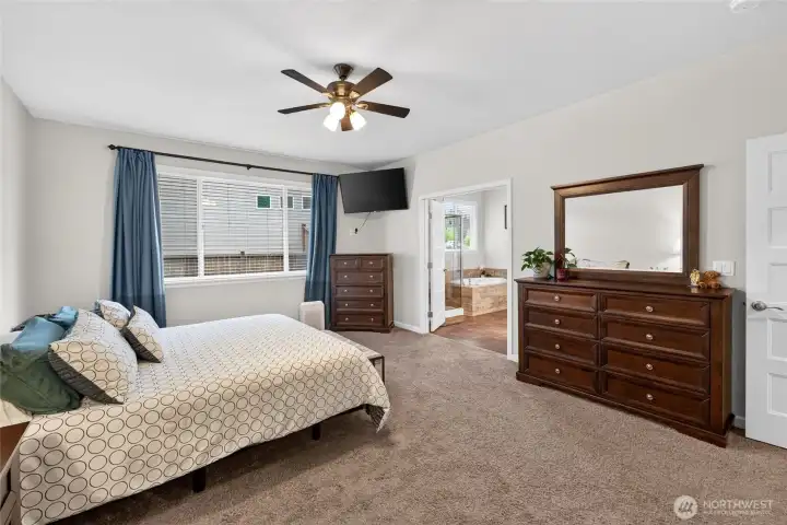 Expansive primary bedroom features abundant natural light and direct access to the luxurious ensuite bath.