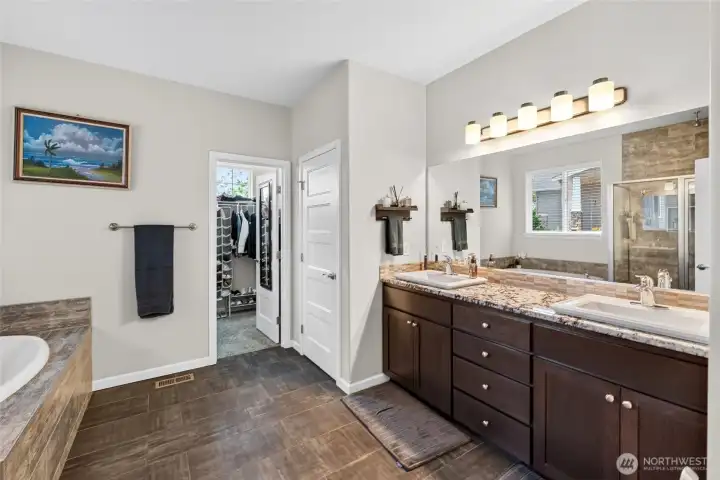 Spa-inspired primary bath showcases dual vanities, abundant storage, and elegant finishes throughout.