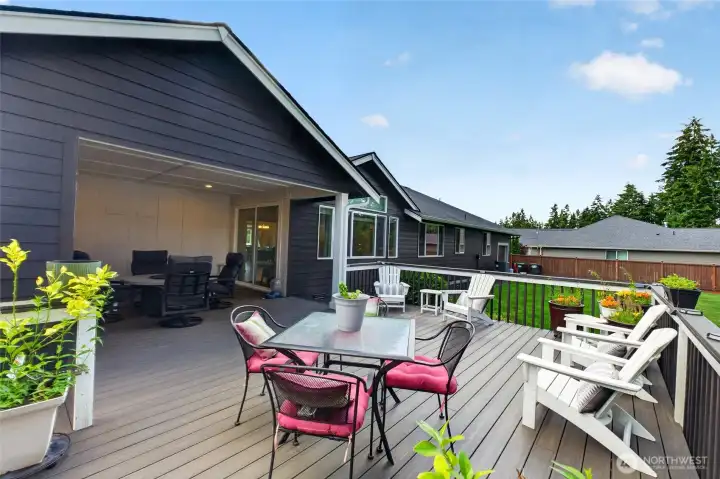 Designed for entertaining, this outdoor retreat offers multiple seating areas and peaceful wooded views.