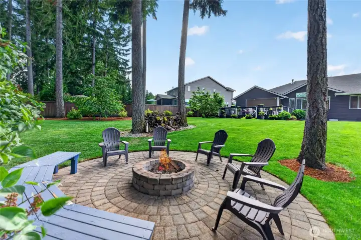 Gather around the custom fire pit and enjoy peaceful evenings with guests beneath towering evergreens.