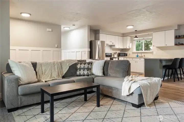 Great room with seating that looks out the big front window.