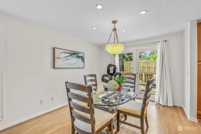 The large dining room sits adjacent to kitchen, complete with decorative light fixture and French door access to the back deck.