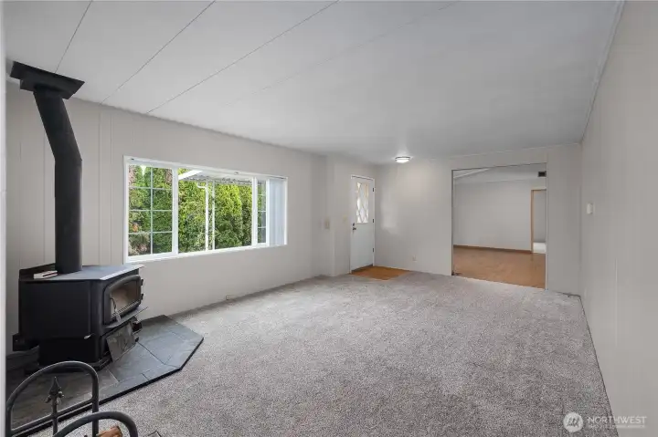 View from 2nd living space to entryway and into primary living room directly ahead. Note the brand new carpeting!