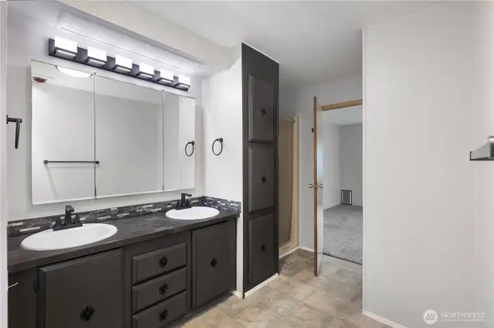 Updated lighting, sinks, faucets, and paint in primary bathroom.