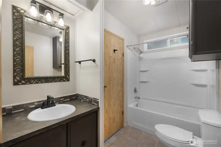 Hallway guest bath is also updated with new lighting, sinks, faucets, and paint. Directly located between additional bedrooms and main living spaces.