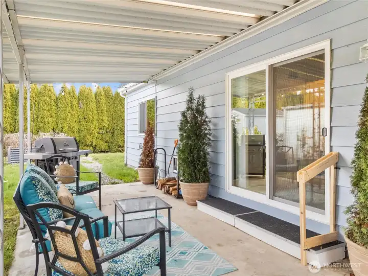View of previous owners set up underneath awning - direct access to backyard with raised garden beds!