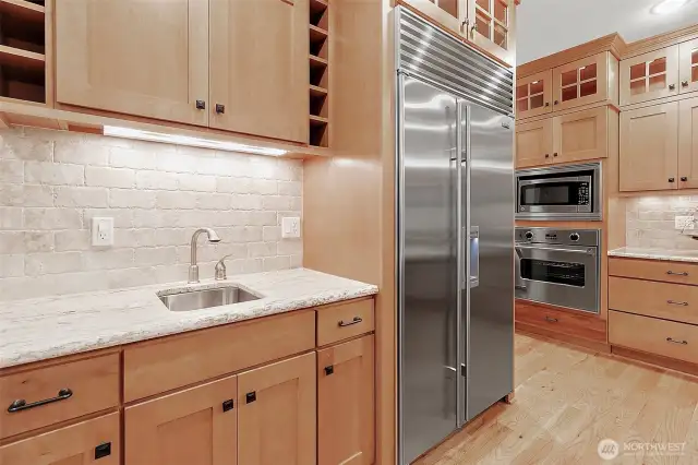 High-end Sub-Zero fridge paired with a convenient secondary sink—perfect for prepping and entertaining with ease.