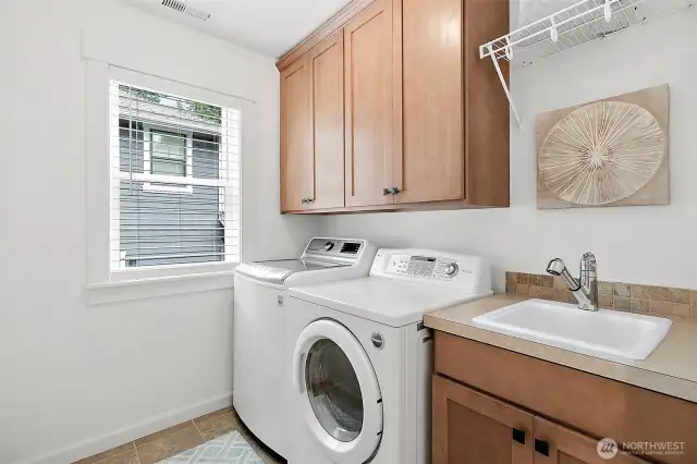 Equipped with a handy sink and ample cabinetry, making laundry tasks organized and efficient.