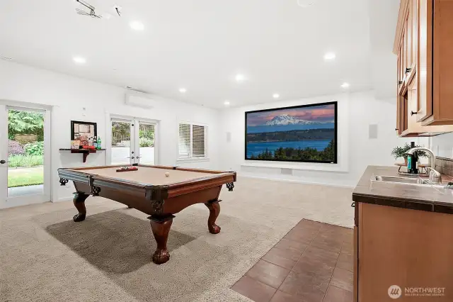 A large bonus room with wet bar, projector setup, and 5th bedroom—perfect for movie nights, guests, or MIL use.