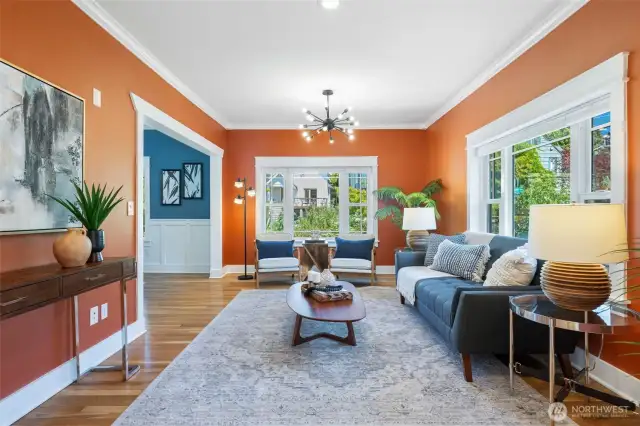 Generous living room/sitting room with walls of updated windows and refinished red/white oak floors.