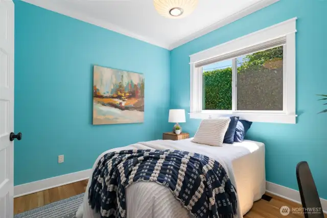 Bedroom one on the 1st floor with original oak hardwoods, great for a kid room, guest or office space.