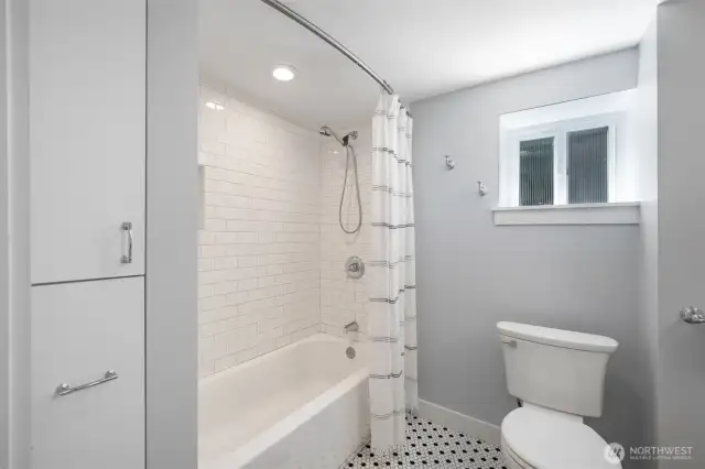Fully tiled surround and newer bathtub. The closets in the photo, pull all the way out for deep storage. There are also large linen closets on both floors.