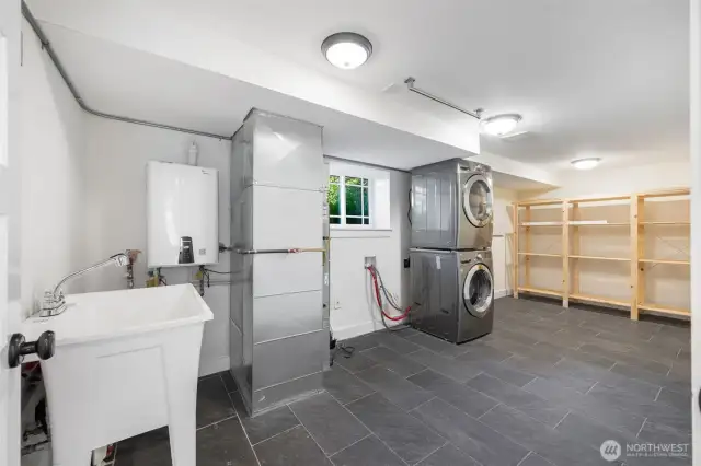 Laundry and storage with on demand hot water, gas furnace with heat pump outside for central heat and air. Added laundry sink and an added 120V plug for a kiln. A great space for art making or other hobbies.