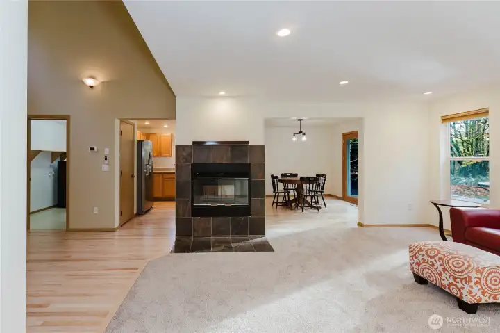 A double sided wood-burning fireplace is open to the family room, kitchen, and dining area.