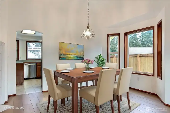 View of the dining room, love the newer flo6oring and windows showcasing your backyard. ***Virtually Staged***