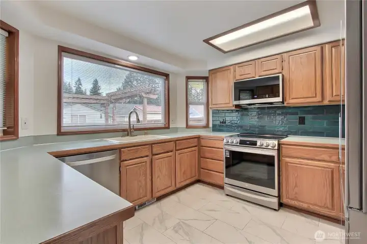 Kitchen view, LOVE the huge windows and all the counter space, newer matching stainless steel appliances.