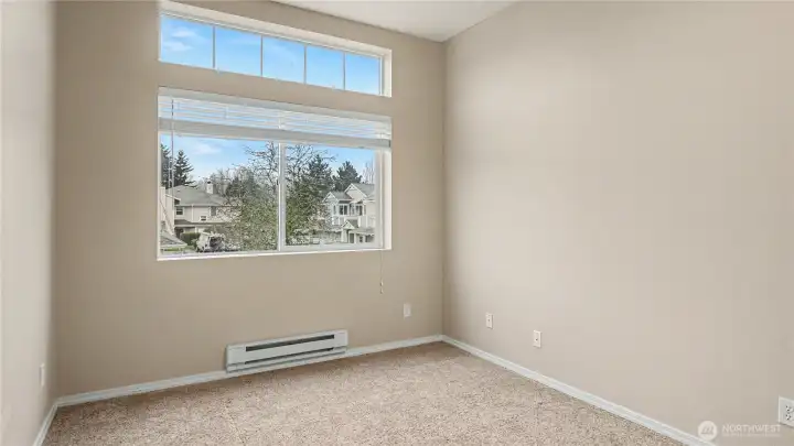 Another view of the inviting guest bedroom, highlighting its spacious layout and ample natural light.