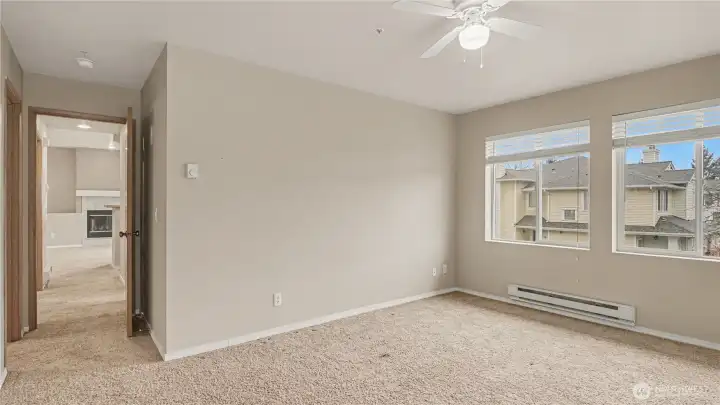 The spacious primary bedroom bathed in natural light, offering a peaceful and refreshing atmosphere to unwind.