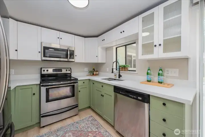 Rennovated kitchen with stainless steel appliances, new countertops, new sink overlooking backyard