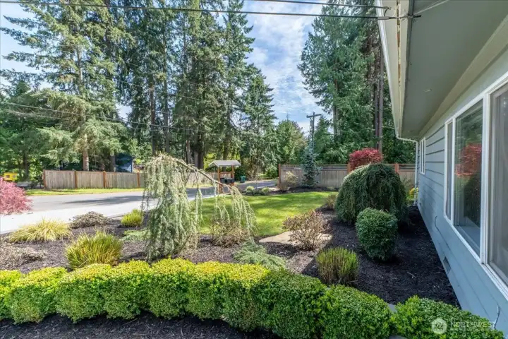 Professionally landscaped front yard with water feature and retaining wall