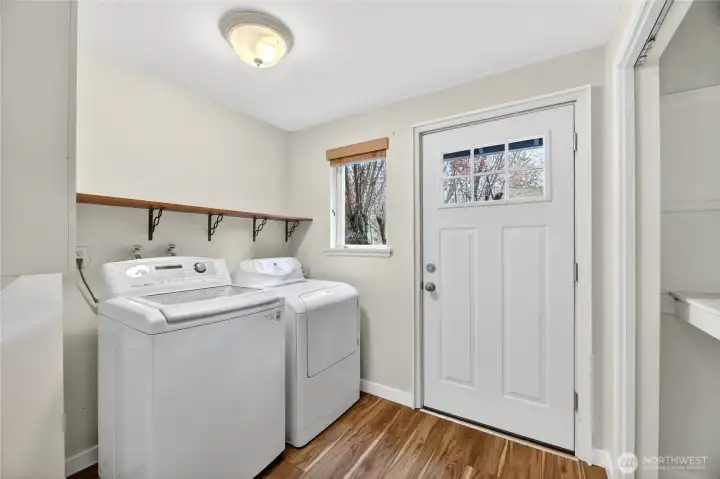 LAUNDRY / MUD ROOM  Wide HALLWAY  Laundry area with washer and dryer / Upper cabinets  Folding counter  Door leading to stairs to side yard and driveway