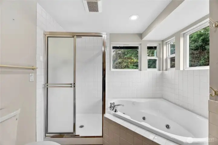 Corner jacuzzi tub with tile surround, and upper window that open for fresh air  New walk-in shower with handheld and rain shower head / Tile surround / Glass block accent wall