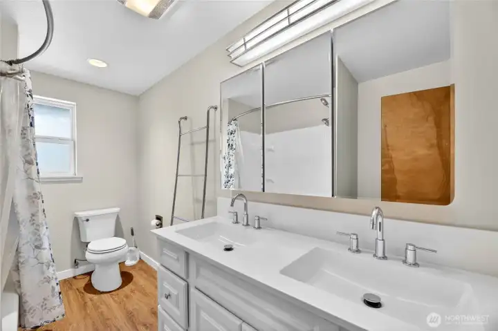 REMODELED HALL BATHROOM - 2026  Vanity with dual sinks / Mirrored medicine cabinet / Storage nook/alcove  Window / Tub/Shower / LVP floor