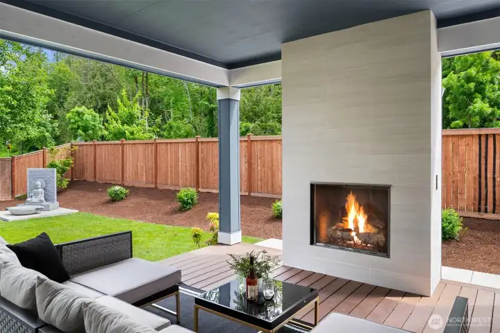 Designed for seamless year-round entertaining, the covered outdoor room is anchored by a cozy fireplace and connected to the main living spaces through dramatic double sliding doors that create effortless indoor-outdoor flow.