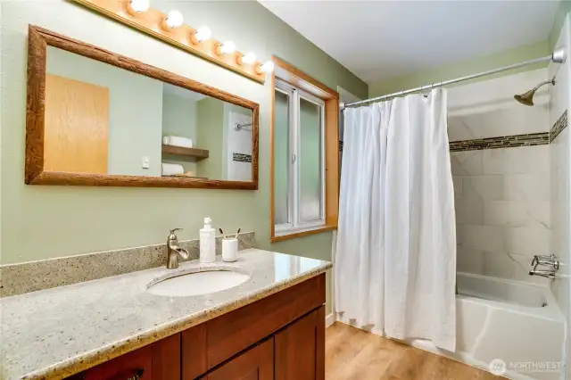 Updated full bath with granite vanity, deep soaking tub, and earthy tones—balancing style with everyday function.