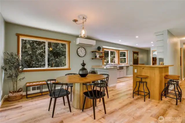 Light-filled dining nook and breakfast bar offer casual gathering space with views of the trees—perfect for everyday meals or weekend brunch.