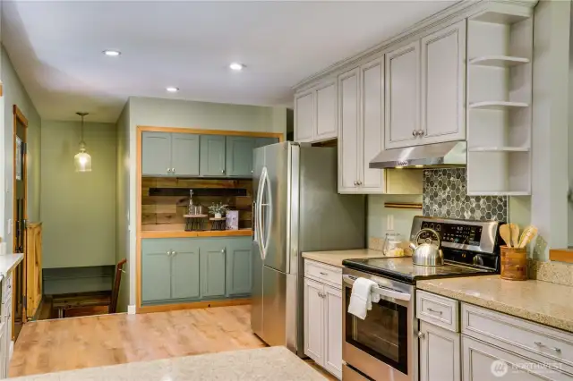 Thoughtfully updated kitchen includes custom cabinetry, modern backsplash, and built-in beverage bar—ideal for entertaining or coffee rituals.