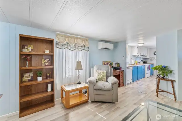 Living room with mini-split to keep the home cool. Leads into kitchen/dining room