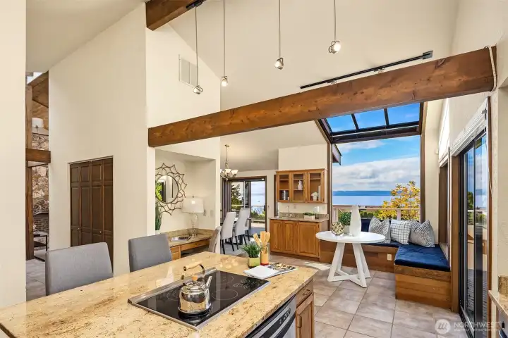 From the kitchen, you can see the circular floor plan—left of the island, a hallway leads to the front door, coat closet, and a conveniently located powder room.