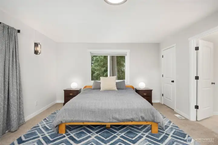 Large primary bedroom with private balcony, two closets & ensuite bathroom