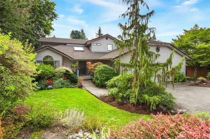 Front view of this beautiful, secluded home. All exterior photos were taken in August 2025 to highlight the park-like setting.