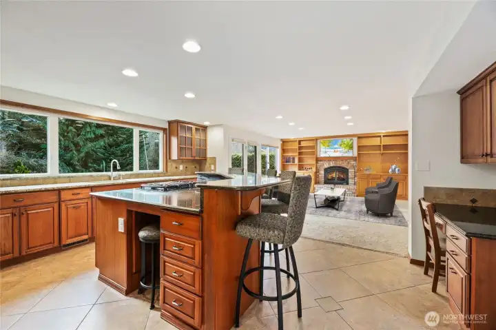 Expansive center island with prep space and seating, complemented by a desk to the right. Barstools and kitchen desk chairs can stay if desired. Image is virtually staged for visualization purposes.
